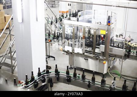 La production industrielle tourné avec des bouteilles de champagne sur le convoyeur à bande dans une usine Banque D'Images