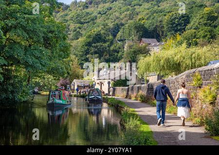 Couple marchant avait en main le long du canal Rochdale dans la ville de marché de Calderdale Valley de Hebden Bridge West Yorkshire Angleterre Banque D'Images