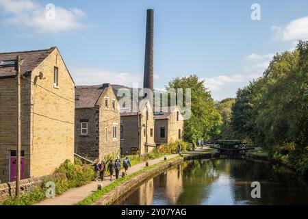 Les gens marchent le long du chemin de halage du canal de Rochdale qui traverse la ville marchande de Hebden Bridge England dans le West Yorkshire Banque D'Images