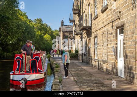 Les gens sur un bateau étroit de canal sur le point de s'amarrer sur le canal de Rochdale dans la vallée de Calderdale du West Yorkshire ville de marché de Hebden Bridge Angleterre Banque D'Images