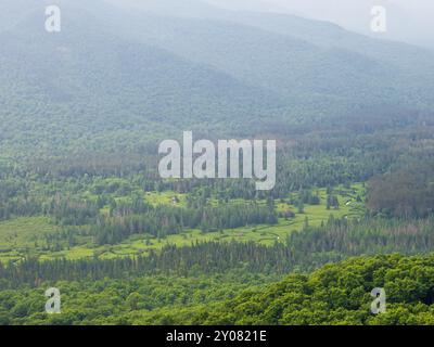 Du sommet du Mt. Van Hoevenberg, contemplez South Meadow Brook niché dans la vallée, avec de la brume roulant sur les sommets lointains des Adirondacks à proximité Banque D'Images