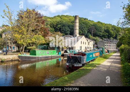 Les bateaux étroits de canal amarrés par l'ancien moulin Crossleys sur le canal de Rochdale dans la ville de marché de Calderdale Valley de Hebden Bridge West Yorkshire Angleterre Banque D'Images