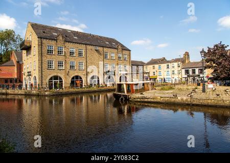 Le canal étroit mouillait le long d'anciens bâtiments de quai de canal sur le canal de Rochdale dans la ville de marché de Calder Valley West Yorkshire de Hebden Bridge Banque D'Images