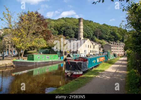 Les bateaux étroits de canal amarrés par l'ancien moulin Crossleys sur le canal de Rochdale dans la ville de marché de Calderdale Valley de Hebden Bridge West Yorkshire Angleterre Banque D'Images