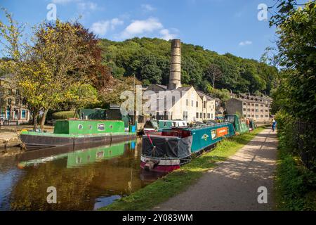 Les bateaux étroits de canal amarrés par l'ancien moulin Crossleys sur le canal de Rochdale dans la ville de marché de Calderdale Valley de Hebden Bridge West Yorkshire Angleterre Banque D'Images