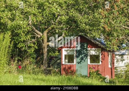 Maison en bois rouge dans un jardin Banque D'Images