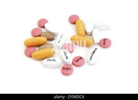 Différentes pilules avec des signes espoir, beauté, amour, confiance sur fond blanc Banque D'Images