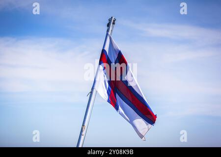 Le drapeau national des îles Féroé souffle dans le vent Banque D'Images