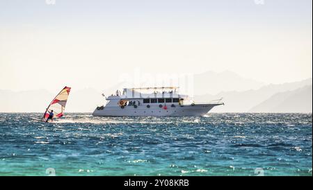 Grand bateau et un surfeur dans la mer sur fond d'une côte rocheuse en Egypte Dahab Banque D'Images