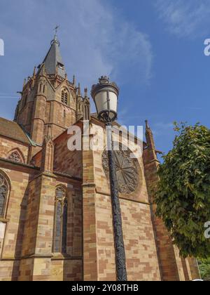 Détail d'une tour d'église gothique avec de grandes fenêtres et une lanterne de rue décorative, Weissenburg, Alsace, France, Europe Banque D'Images