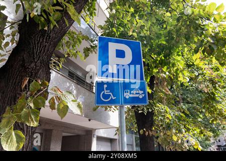 Parking réservé aux conducteurs handicapés. Espace de stationnement gratuit pour PWD ; indiqué par des marquages routiers et un panneau d'information. Espaces adaptés aux personnes handicapées. Po Banque D'Images