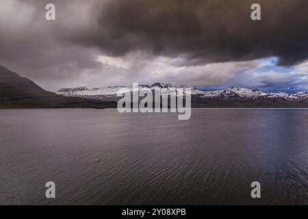 Montagnes enneigées des fjords orientaux avec un ciel couvert sur l'Islande Banque D'Images