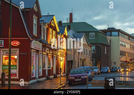 REYKJAVIK, ISLANDE, 06 JUILLET : le centre-ville la nuit avec des voitures garées sur une place devant un imposiing lumineux Buidling dans un quartier commerçant Banque D'Images