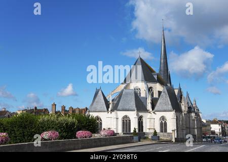 Gotische Kathedrale mit hohen Tuermen und einem klaren Himmel mit Blumen im Vordergrund, Kirche, Eglise Saint-Jean-Baptiste, Nemours, Fluss Loing, DEP Banque D'Images