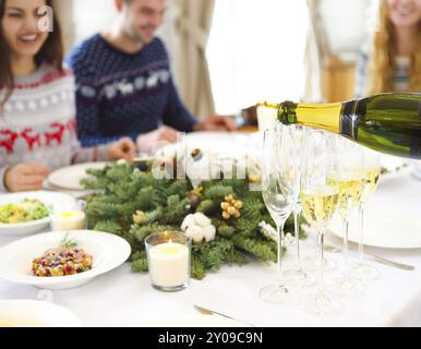 Pouring champagne verres en un comité permanent sur la table de Noël Banque D'Images