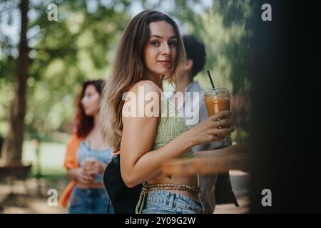 Amis achetant des boissons à un camion de boisson dans le parc par une journée ensoleillée Banque D'Images