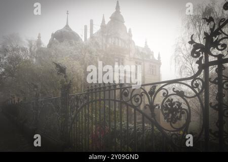 Ancienne villa avec clôture en fer dans la brume du matin Banque D'Images