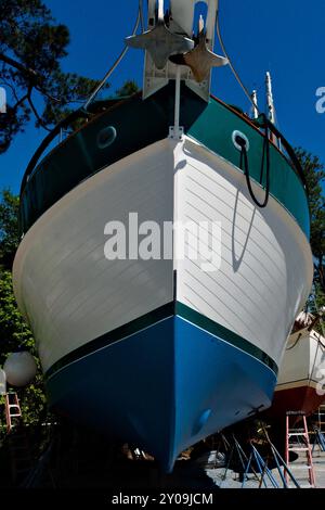 Une image de la proue d'un bateau qui est assis sur des chandelles dans une marina en attente de réparations. Banque D'Images