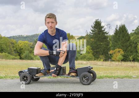 Young caucasian man électriques lecteurs de nature route sur mountainboard Banque D'Images