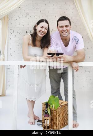 Jeune couple heureux dégustant un verre de vin rouge sur la terrasse Banque D'Images