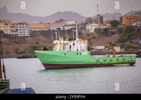 Navire vert quittant le port dans la matinée Banque D'Images