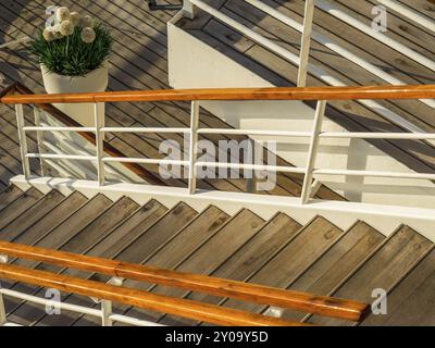 Escalier en bois sur un pont de navire avec garde-corps orange et une plante en pot, stockholm, mer baltique, suède, scandinavie Banque D'Images