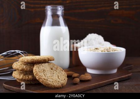 Les cookies d'avoine fait maison et les ingrédients pour la cuisson sur planche de bois rustique Banque D'Images