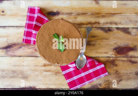 Tiramisu gâteau dans une tasse en verre sur fond de bois. Désert italien mascarpone Banque D'Images