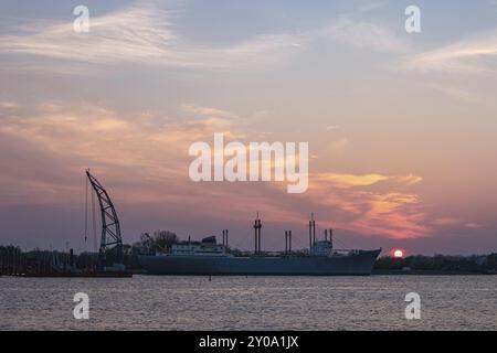 Vue à travers la Warnow jusqu'au bateau traditionnel à Rostock au coucher du soleil Banque D'Images