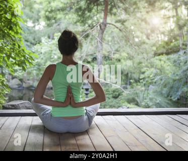 Young woman doing yoga asana dans la soirée à l'extérieur Banque D'Images