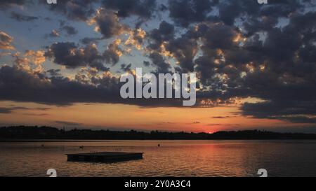 Scène de soirée idyllique à Auslikon. Coucher de soleil sur le lac Pfaeffikersee. Beaux nuages d'été Banque D'Images