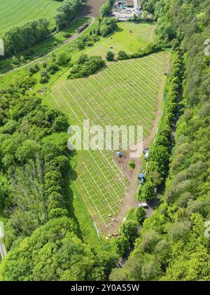 Vue aérienne d'un parc solaire en construction, entouré de champs verts et de forêts dans le paysage rural, construction de la Forêt Noire nature Banque D'Images