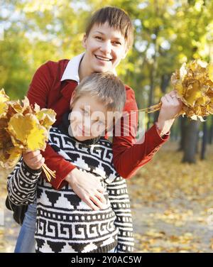 Mère et son fils marchant dans un parc d'automne Banque D'Images