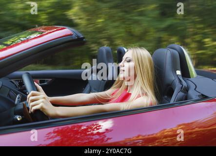 Belle blonde woman driving a car Banque D'Images