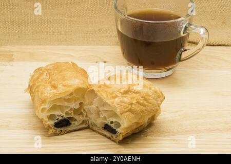 Bâton de chocolat danois et rempli une tasse de café sur planche de bois Banque D'Images