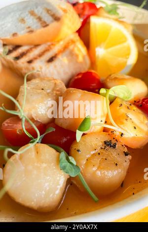 Coquilles Saint-Jacques portugaises frites dans une sauce au vin blanc avec citron, tomates et pain grillé. Fruits de mer, régime méditerranéen. Banque D'Images