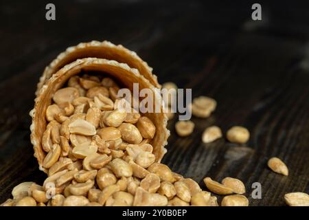 Cacahuètes croustillantes rôties dans un cône de gaufre pour la crème glacée, un bouquet de cacahuètes mûres et délicieuses avec une gaufre Banque D'Images