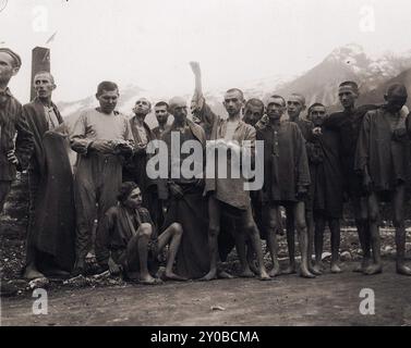 Un groupe de survivants émaciés d'Ebensee. Ebensee était un sous-camp du camp de concentration de Mauthausen construit par les SS en 1943 pour construire des tunnels pour le stockage d'armements près de la ville d'Ebensee, en Autriche. Bien que le complexe de Mauthausen n'était pas un centre d'extermination, la cruauté et la négligence étaient monnaie courante. Entre 8 500 et 11 000 prisonniers sont morts dans le camp, principalement de faim ou de malnutrition. L'armée américaine libère le camp le 6 mai 1945. Banque D'Images