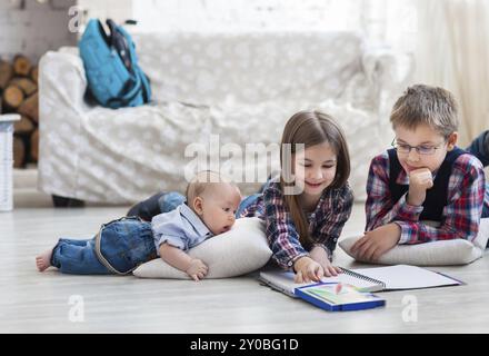 Frère et soeur le dessin avec des crayons de couleur dans la salle de séjour avec petit frère Banque D'Images