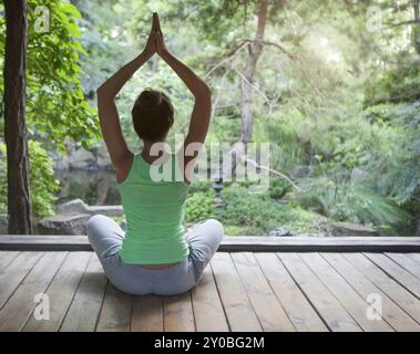 Young woman doing yoga asana dans la soirée à l'extérieur Banque D'Images