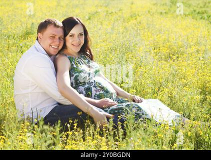 Young happy pregnant couple dans le parc printemps floraison. Portrait en extérieur Banque D'Images