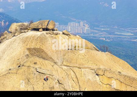 Alpinistes grimpant le rocher Insubong, le deuxième plus haut sommet de la montagne Bukhansan avec vue sur la ville ci-dessous à Séoul, Corée du Sud, Asie Banque D'Images