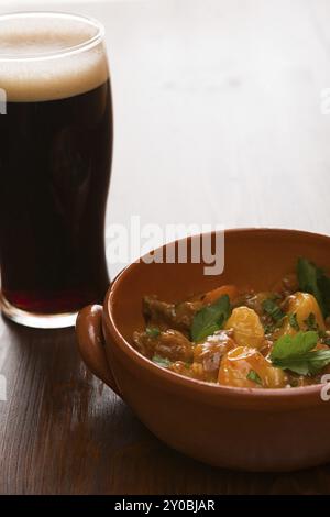 Ragoût irlandais traditionnel sur un bol brun avec une pinte de bière sur une table Banque D'Images