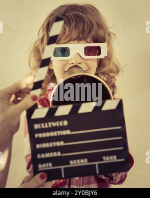 Kid holding clapper board dans les mains. Cinema concept. Retro style Banque D'Images