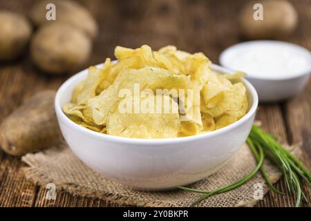 Croustilles de pommes de terre de crème sure (goût) sur fond de bois rustique (gros plan) Banque D'Images