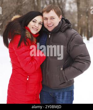 Happy young couple having fun in the winter park Banque D'Images