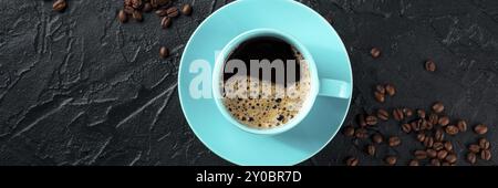 Tasse de café bleu et panorama des grains de café, plan de pose aérienne sur un fond de pierre noire avec espace de copie, une bannière panoramique pour un menu, pho alimentaire Banque D'Images