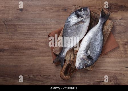 Poisson dorado cru frais, sur une planche à découper, table en bois, vue de dessus, deux morceaux, pas de gens Banque D'Images