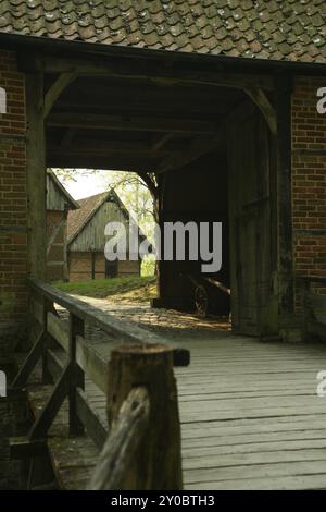 Vue d'une ancienne ferme depuis un pont à travers une porte d'entrée Banque D'Images