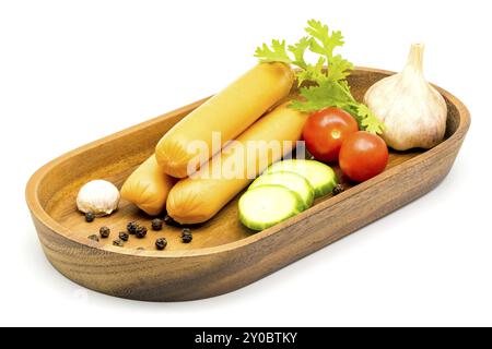 Les saucisses, les légumes, l'ail et les poivrons dans le bac en bois noir sur fond blanc Banque D'Images